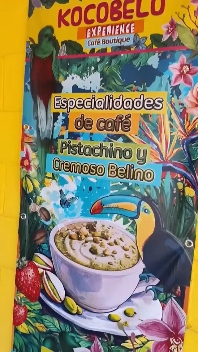El cartel del café con un tucán, una taza de café de pistacho y flores tropicales